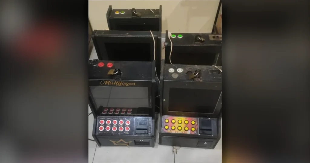 Caça-níqueis em Arapongas apreendidos pela Polícia Militar enfileirados dentro de uma delegacia sob iluminação artificial.