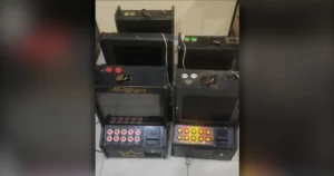 Caça-níqueis em Arapongas apreendidos pela Polícia Militar enfileirados dentro de uma delegacia sob iluminação artificial.