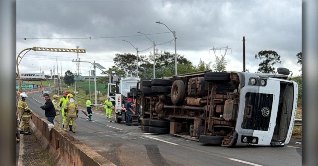 Caminhão tombado na rodovia durante acidente em Arapongas com a presença de socorristas