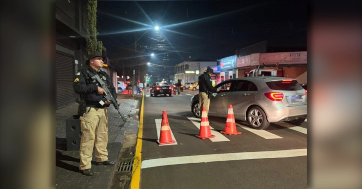Policial militar realiza teste do bafômetro em motorista durante fiscalização de embriaguez ao volante em Arapongas.