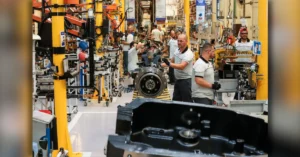 Operários trabalhando em linha de produção moderna da indústria do Paraná.